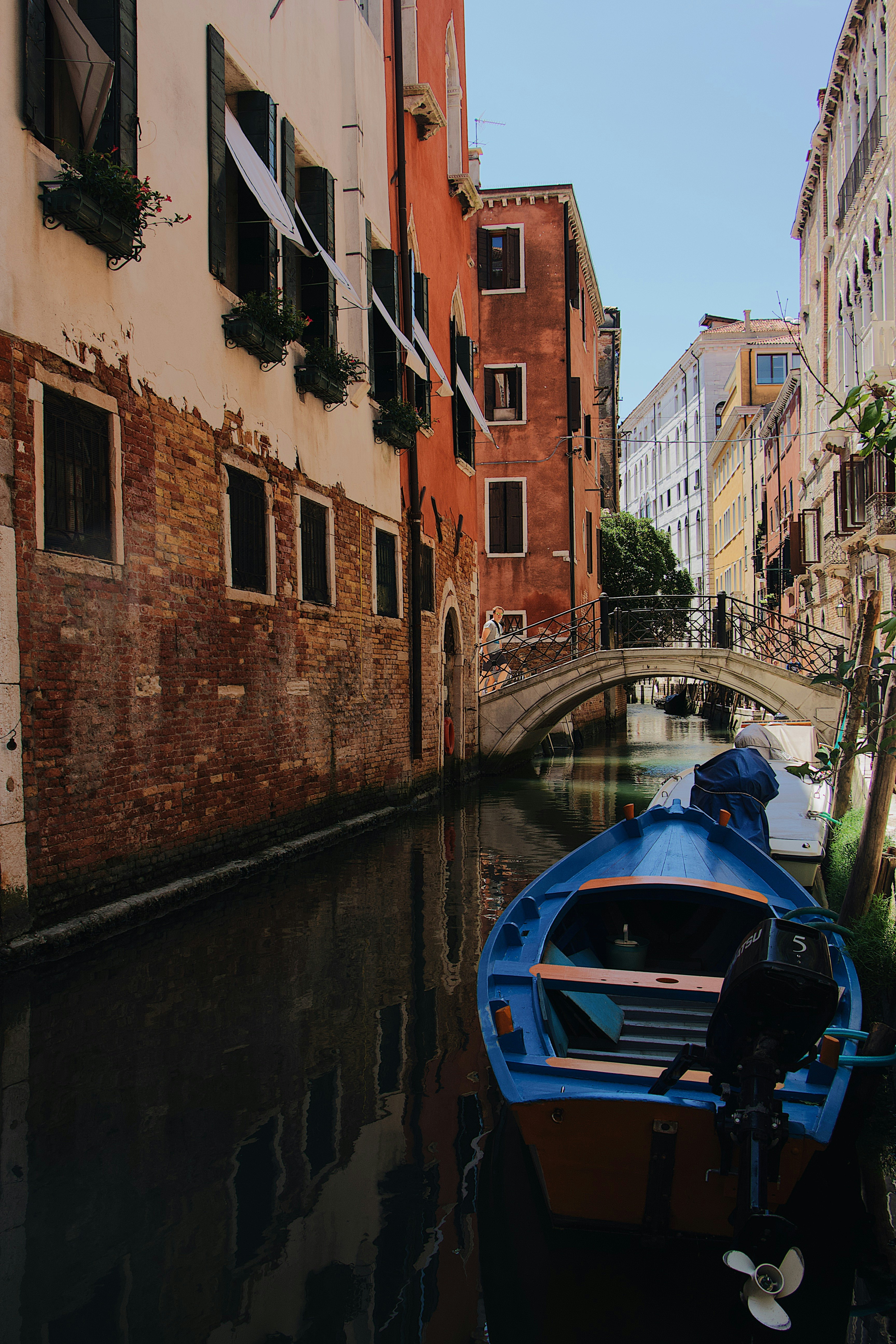 blue boat in the water canal surrounded with houses